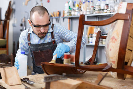 Restorer varnishing vintage chairの写真素材