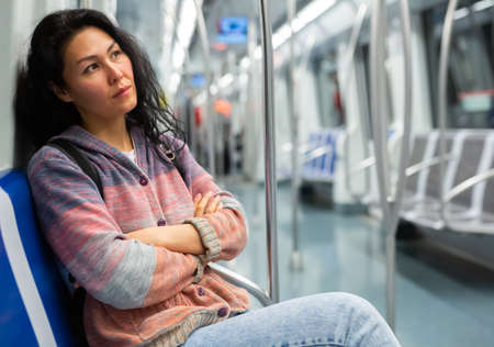 Young woman passenger sitting in subway carの写真素材