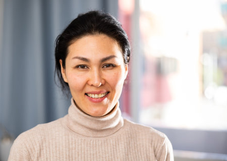 Positive Asian woman looking at camera and smiling