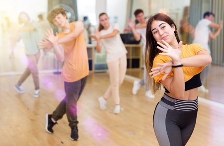 Teens performing modern dance in studio