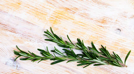Green rosemary on wooden background, top viewの写真素材