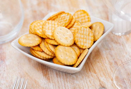 Salted crunchy round crackers served on plate