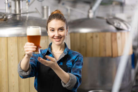 Portrait of positive man brewmaster with glass of beerの写真素材