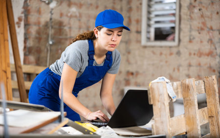 Woman with laptop on indoor construction siteの写真素材