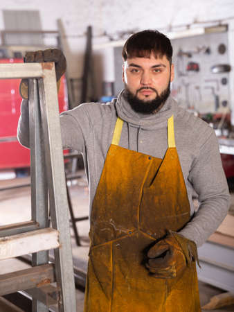 Blacksmith in metalworking workshopの写真素材