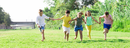 Group of five happy children jogging in a park