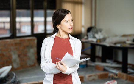 Woman controls the progress of repair work and keeps notes on piece of paper