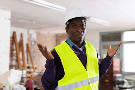 Worried puzzled architect standing in building during renovation
