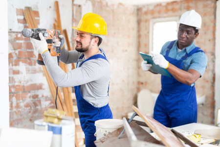 Man builder using electric hammer in construction site