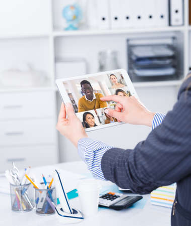 Video conference on smartphone or tablet, business meeting. Communication with business colleagues via video conference closeupの写真素材