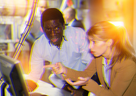 Man and woman in fright looking for a solution on the computer in quest room