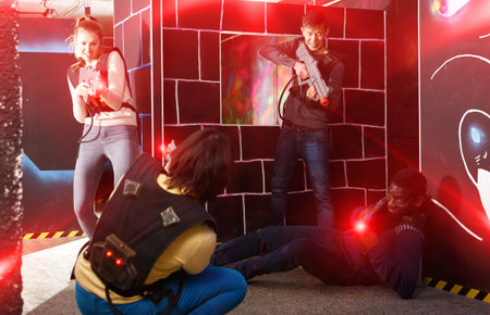 group of adult people with laser guns having funの写真素材
