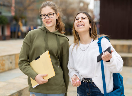 Smiling teenage girls walking after lessonsの写真素材