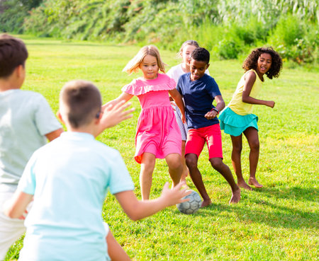 Group of kids playing football on grass