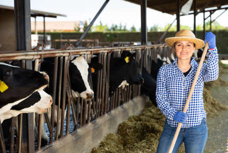 Woman farmer posing at cowshed on farmの写真素材
