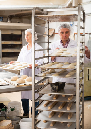 Baker placing tray with formed dough on trolley