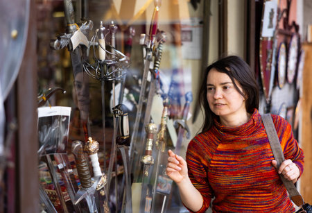 Woman tourist choosing handmade swords