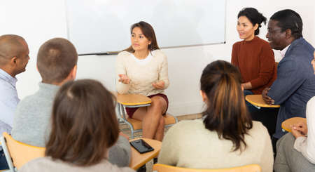 Multicultural people meeting in circle of chairsの写真素材