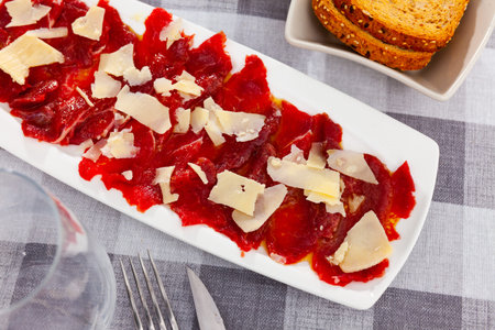 Sliced carpaccio. Raw beef meat on plate