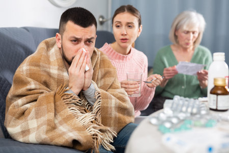 Sick man sitting with wife and mother