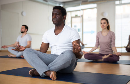 African american man meditating in lotus position with hands folded in mudraの写真素材