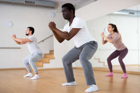 People squatting during fitness trainingの写真素材