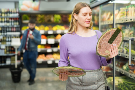 Adult woman choosing semi-finished frozen pizzaの写真素材