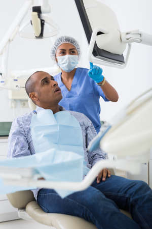 Woman stomatologist explaining treatment to patient in dental officeの素材 [FY310186927854]