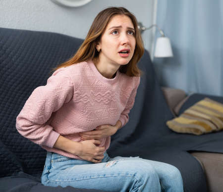 Young woman suffering from abdominal painの写真素材