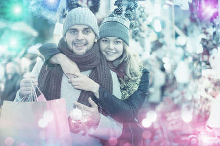 Positive young couple buying decoration at Christmas Fairの写真素材
