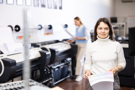 Portrait of positive woman printing office worker with colour schedule