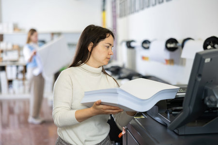 Woman loading ream of paper into printer