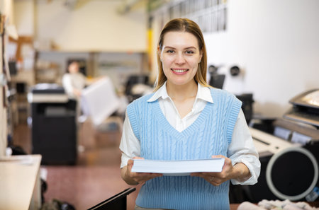 Portrait of happy woman with a stack of paper in her hands in typography