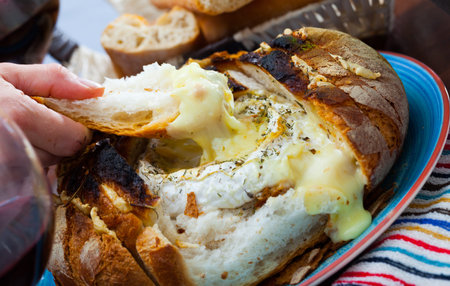 Dish of french cuisine, fresh bread with melted camembert cheese