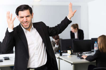 Young businessman standing in office on backround with colleaguesの写真素材