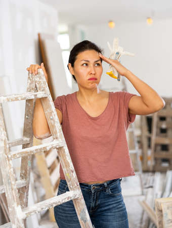 Portrait of overworked asian woman, house renovationの写真素材