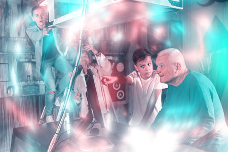 Teenager together with grandfather looking for puzzle solution in quest room