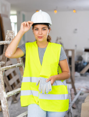 Portrait of positive woman builder during repair worksの写真素材