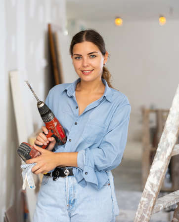 Portrait of a contented young woman with a screwdriver in handsの写真素材