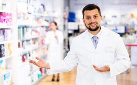 Portrait of positive druggist making presenting gestureの写真素材