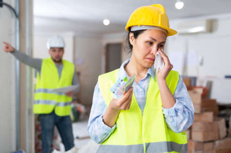 Woman engineer crying, disappointed by low salaryの写真素材