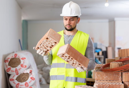 Construction worker checking bricks at renovating objectの写真素材