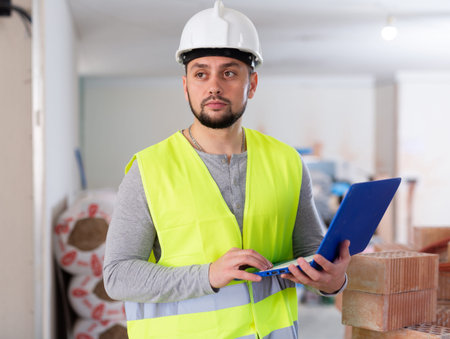 Foreman with laptop on indoor construction site