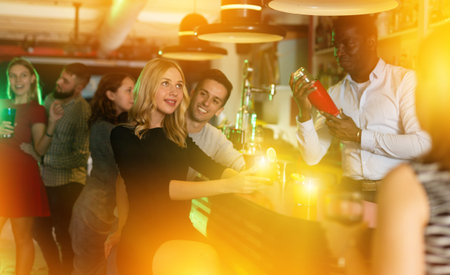 Charming girl flirts with a man in night barの写真素材