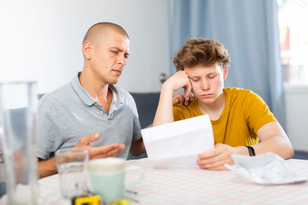 Depressed father and son reading letter