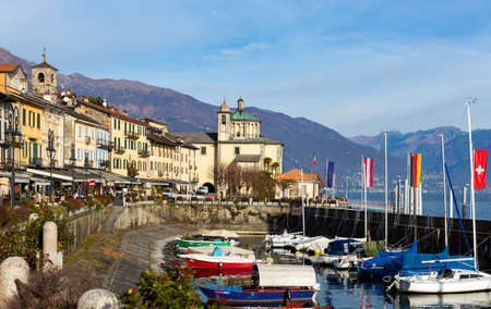 Promenade in Cannobio on Lake Maggiore overlooking church and harbor with boatsのeditorial素材