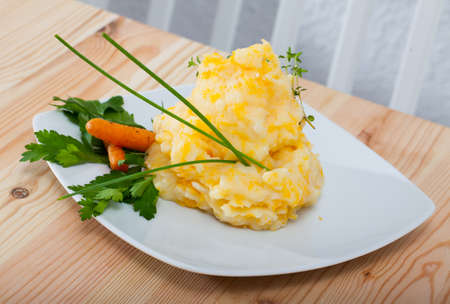 Traditional dish of Scottish cuisine - Clapshot served with baked carrots and greensの写真素材