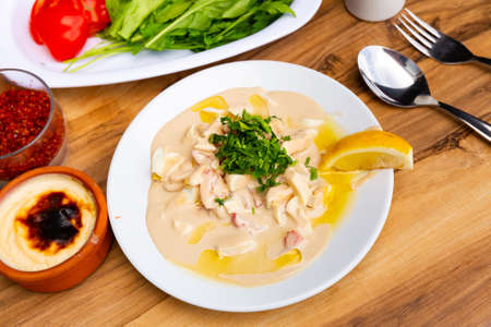 Antalya style piyaz or bean salad with tahini and orange slice on white porcelain plateの写真素材