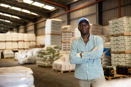 Positive African American man worker posing at warehouseの写真素材