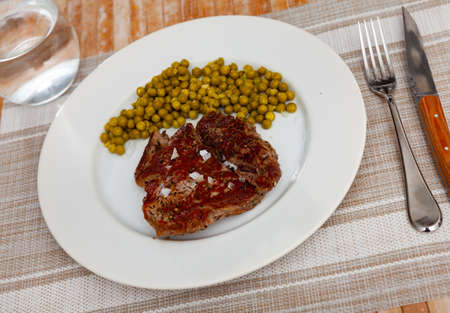Grilled beef steak with pickled green peas on plateの写真素材